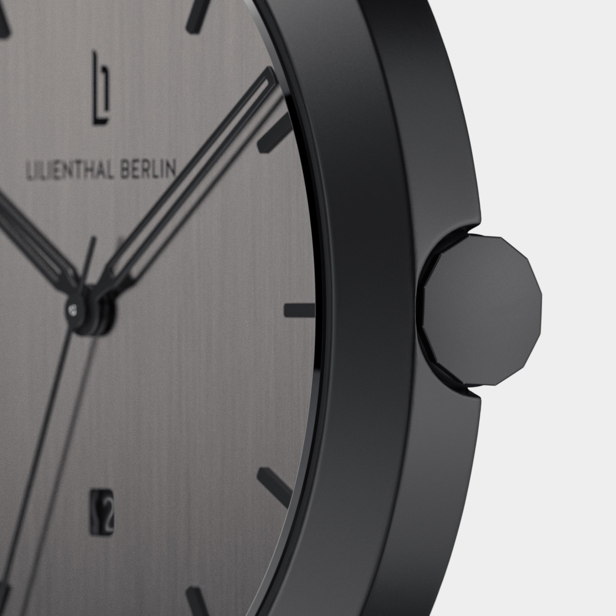 Close-up of minimalist black stainless steel watch with black dial and date window