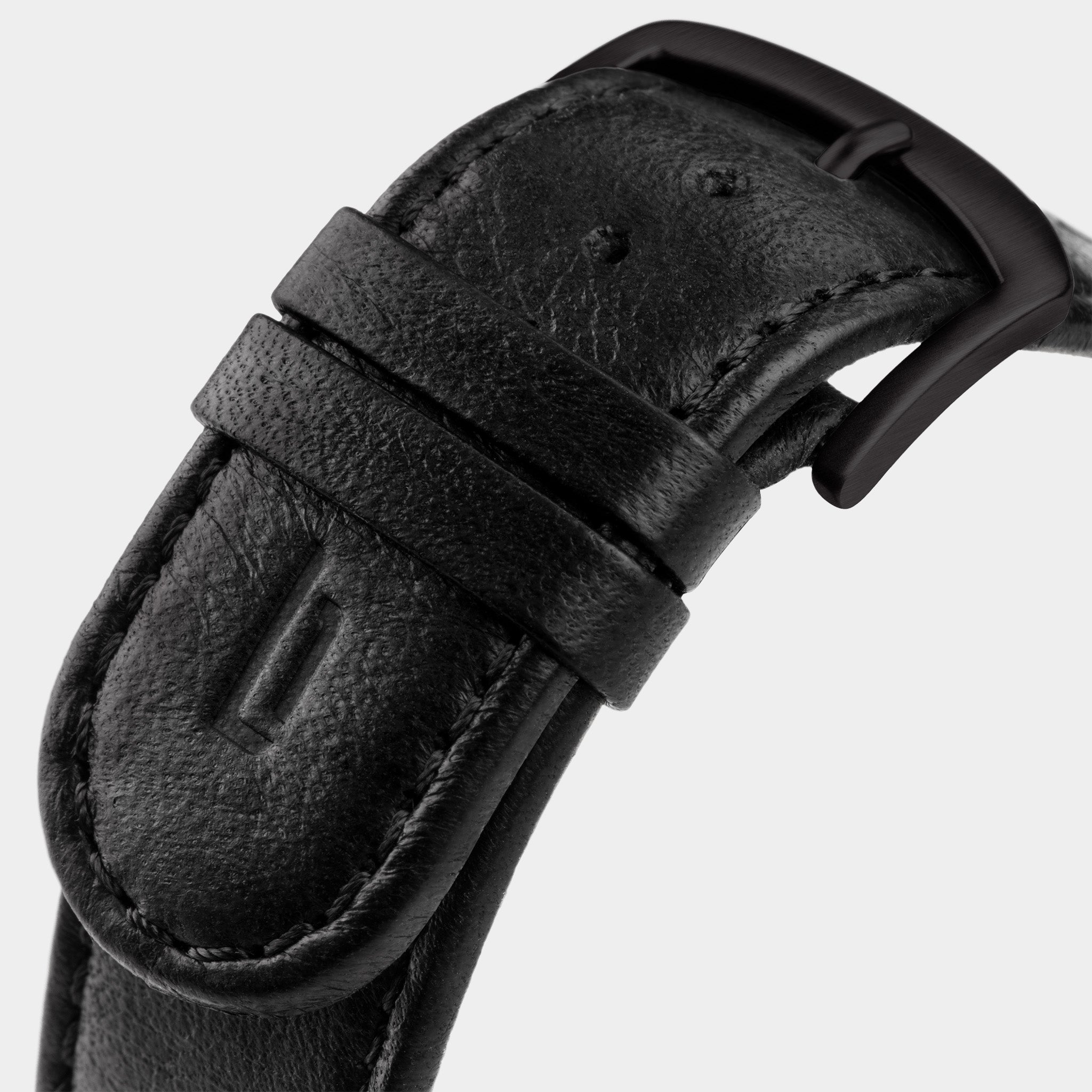 Close-up of black leather watch strap with matte black buckle