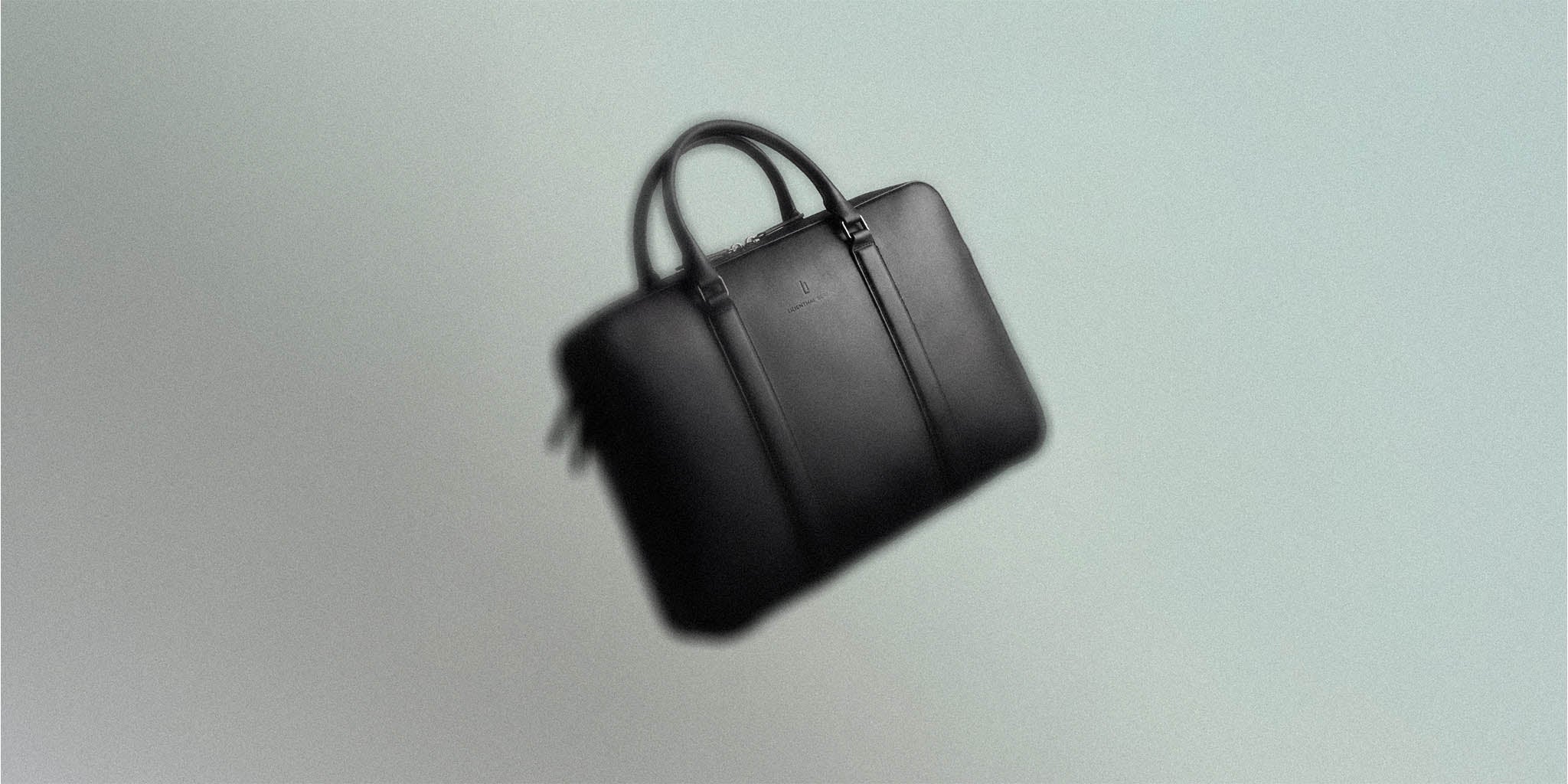 sleek black leather briefcase with dual handles on neutral background