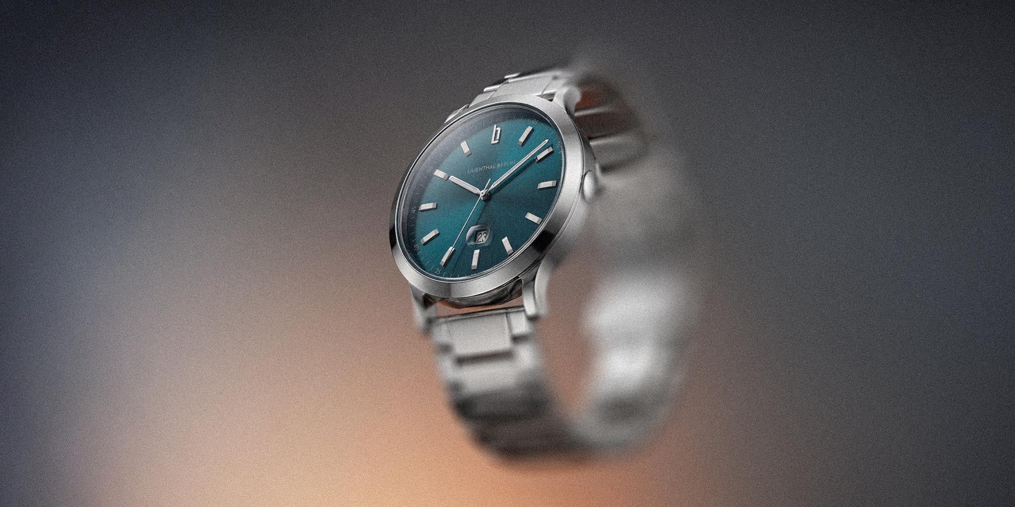 Stainless steel wristwatch with teal dial and date display on gradient background
