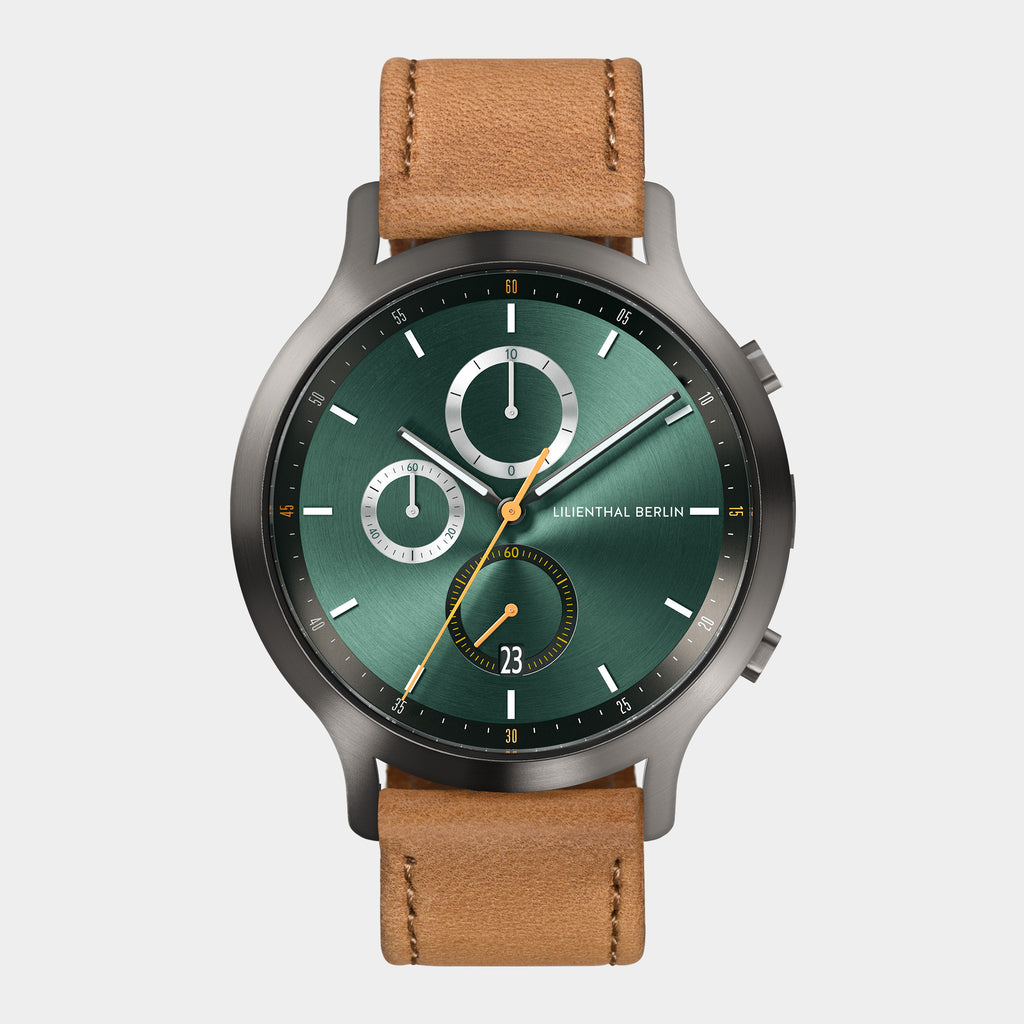 Green chronograph watch with brown leather strap and three subdials on silver bezel