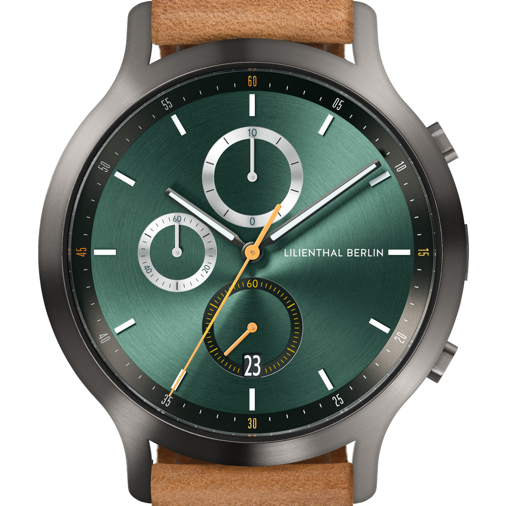 Green chronograph watch face with subdials, date display, and tan leather strap