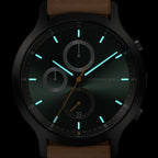 Modern black chronograph watch with luminous hands and markers, brown leather strap, date display