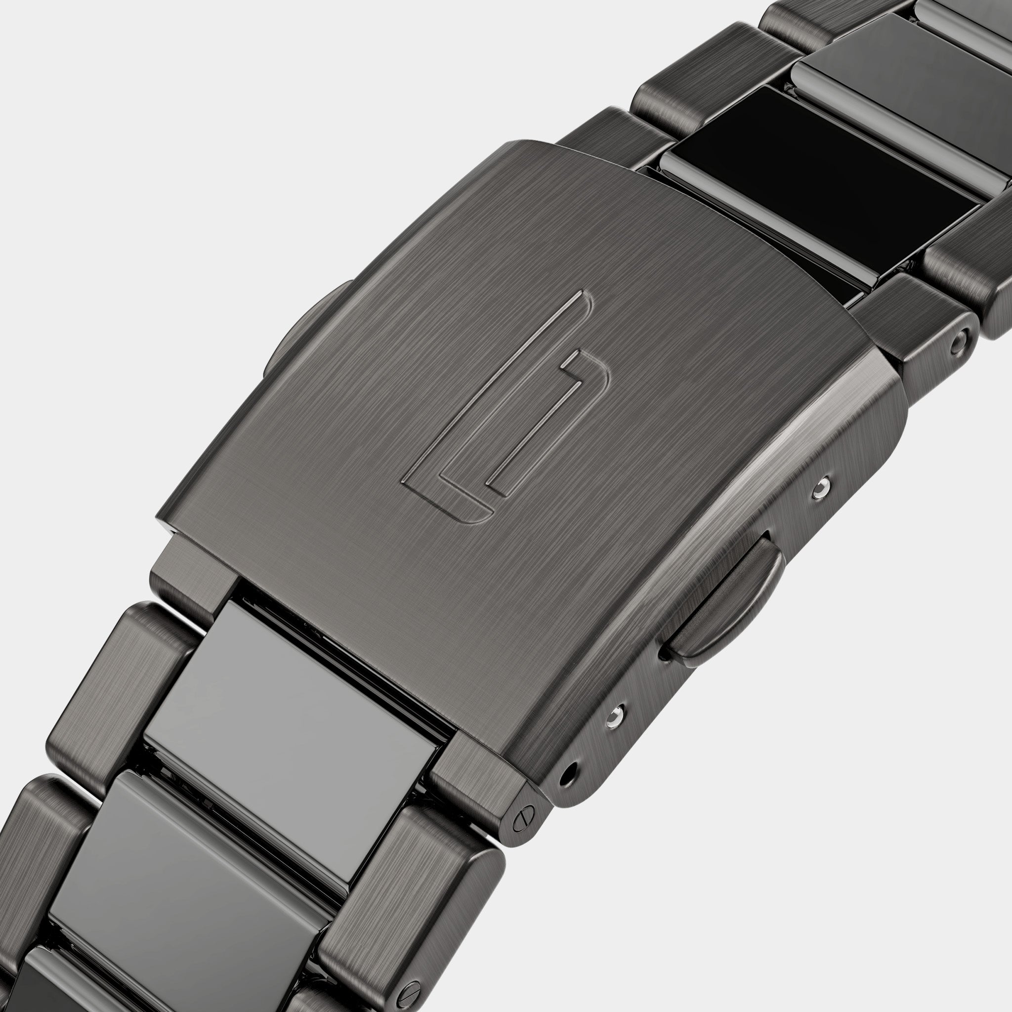 Close-up of brushed metal watch clasp with engraved logo and stainless steel bracelet