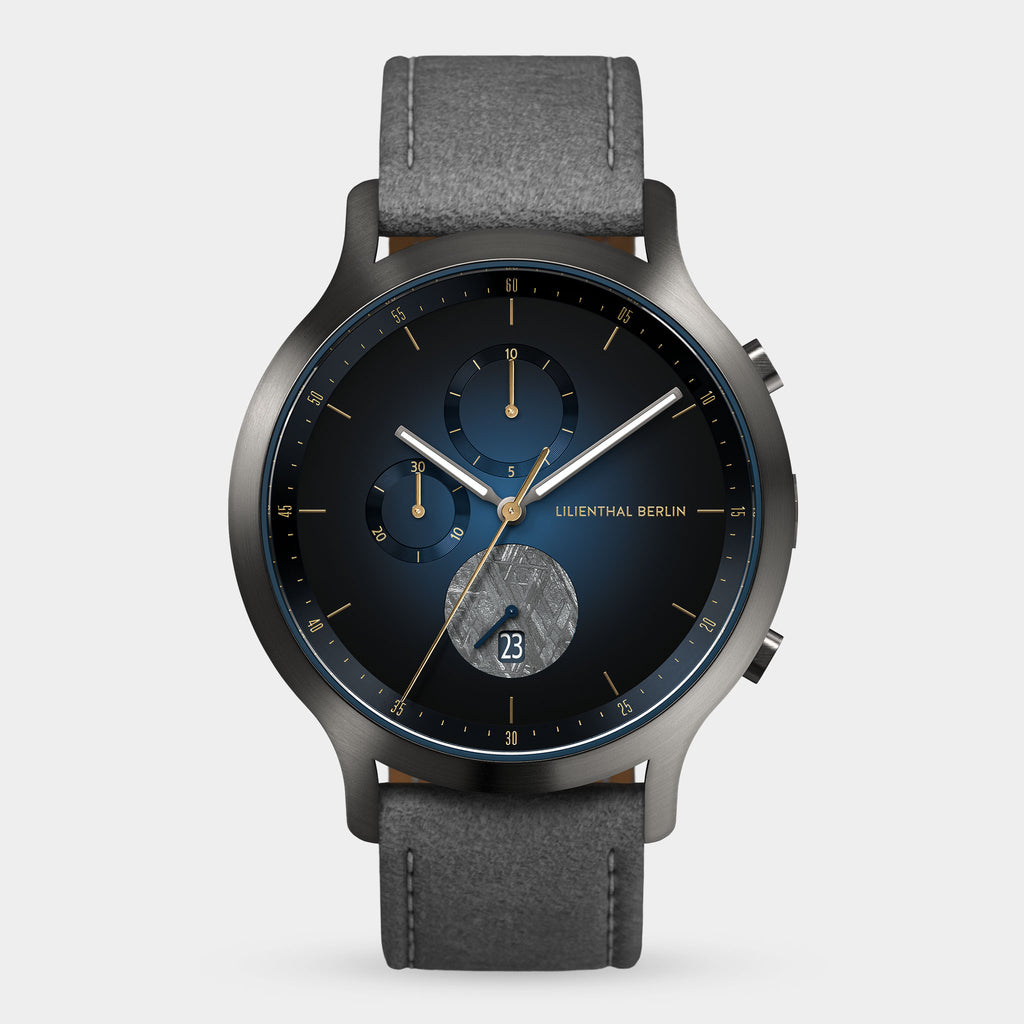 Modern analog wristwatch with blue dial, chronograph subdials, date display, and grey strap