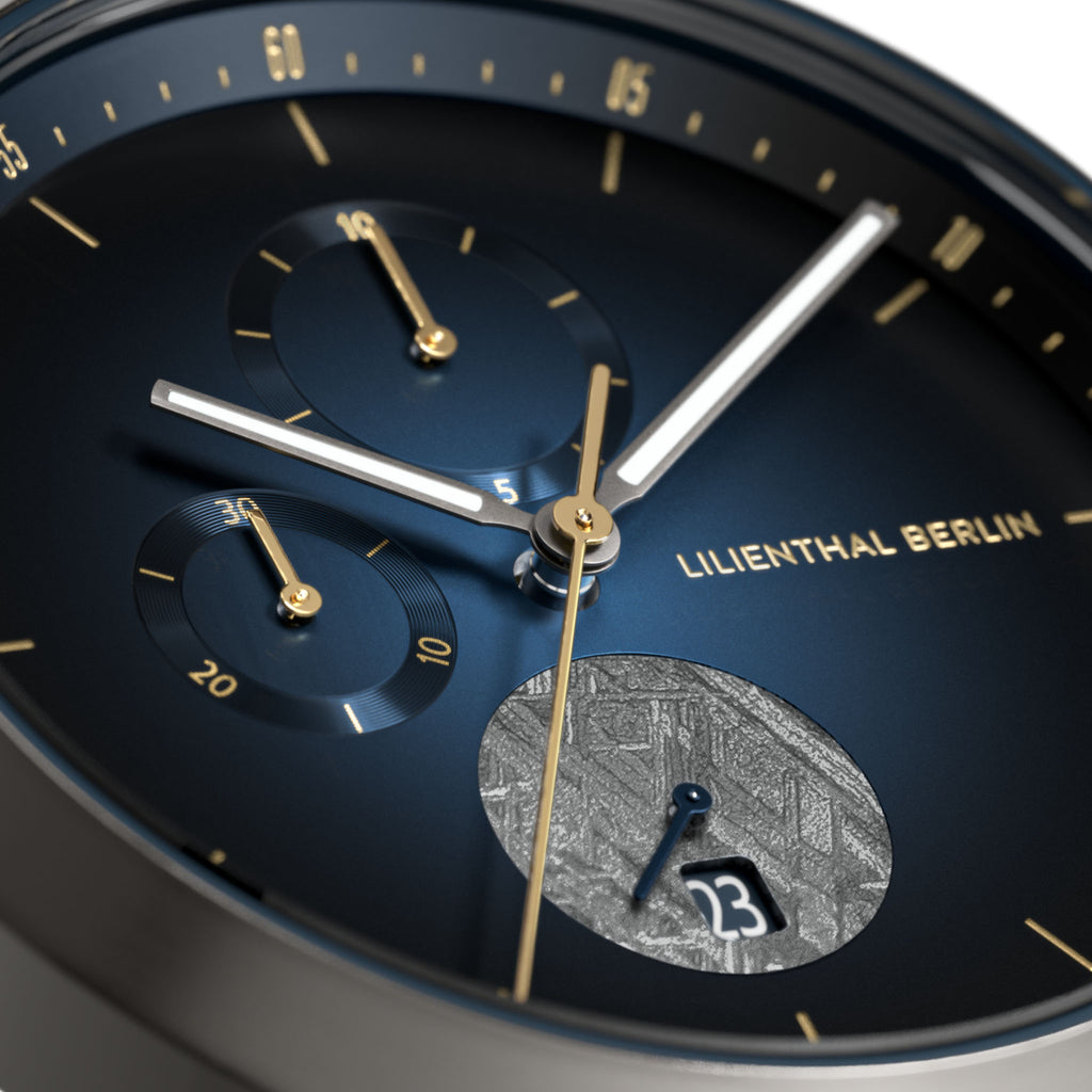 Close-up of blue chronograph watch face with gold accents and date display