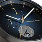 Close-up of blue chronograph watch face with gold accents and date display