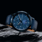 Elegant blue leather watch with subdials and date display on a textured dark stone