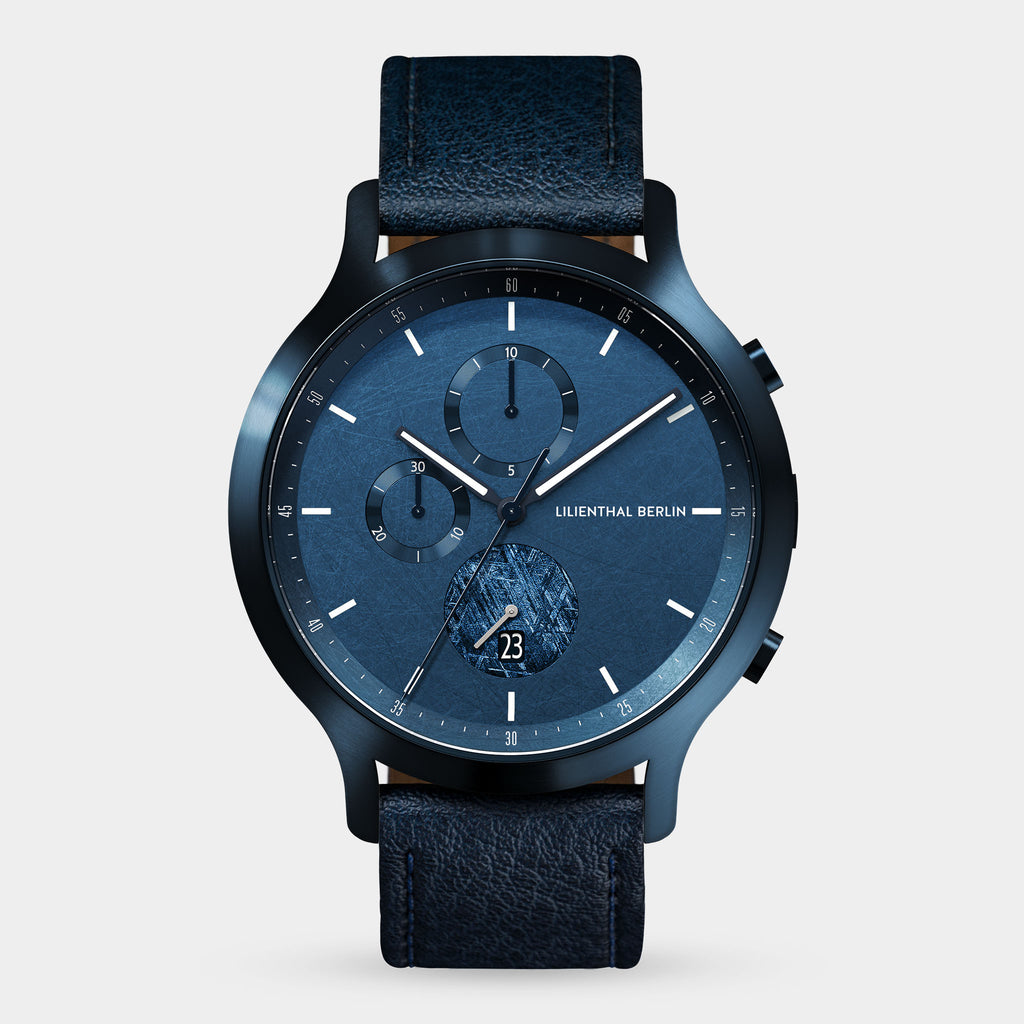 Blue chronograph wristwatch with textured face, date display, and leather strap