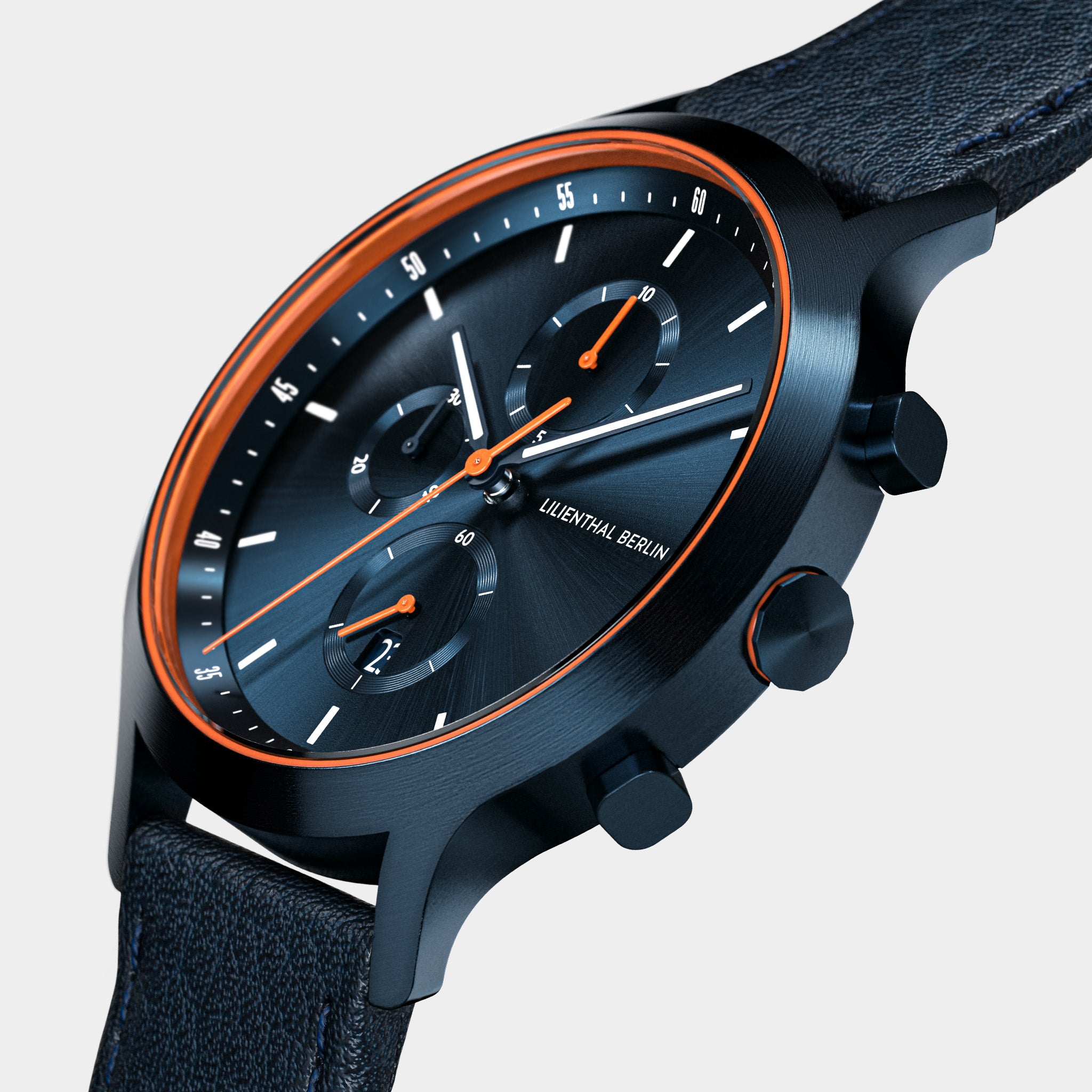 Modern black chronograph watch with orange accents, textured strap, and minimalist dial.