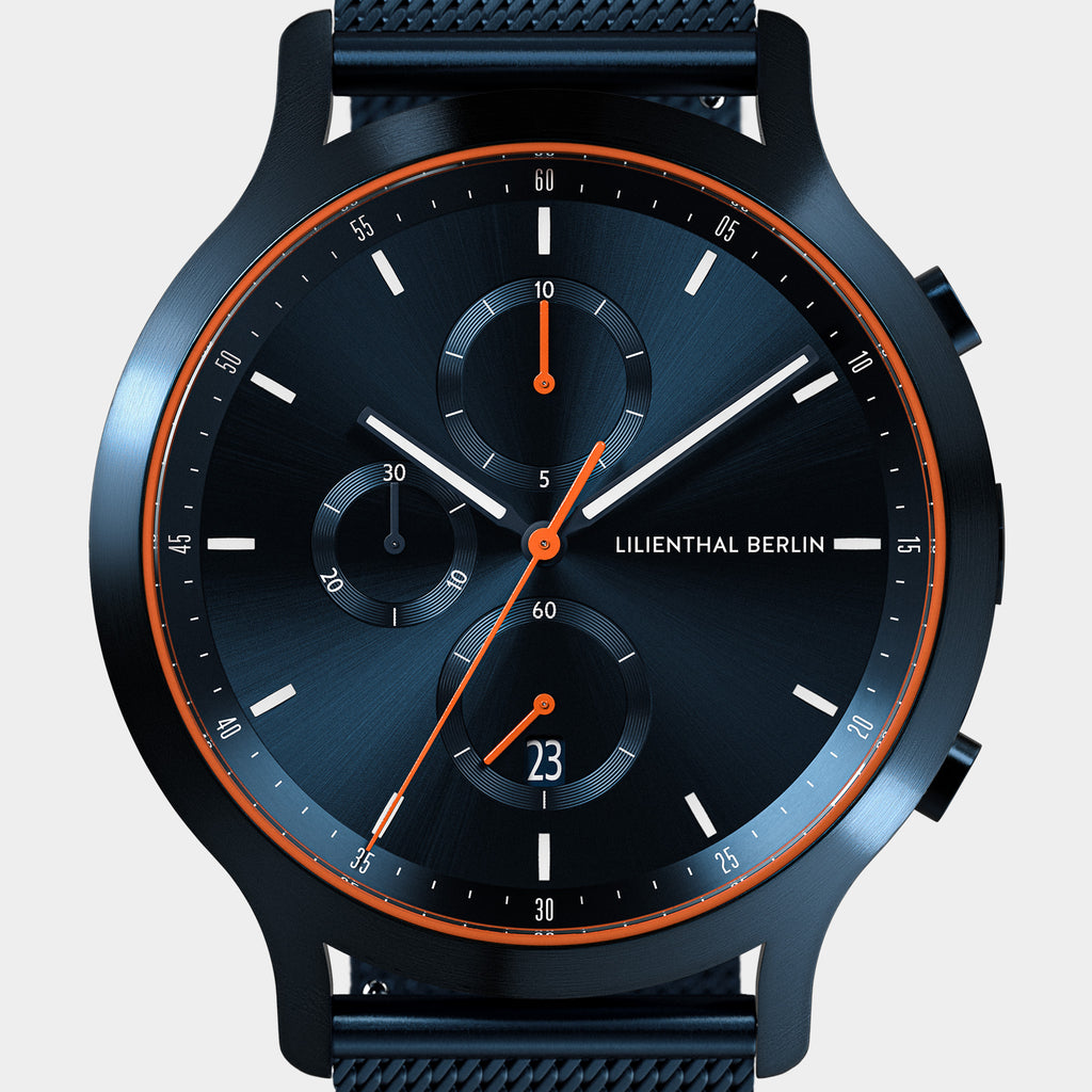 Modern black chronograph watch with orange accents and mesh band, subdials and date display