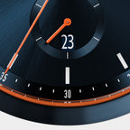 Close-up of a modern black watch face with orange hands, date display, and minimal hour markers