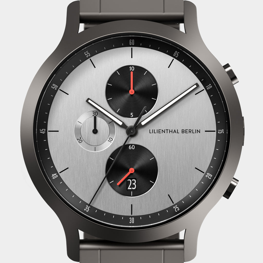 Modern chronograph watch with silver dial, black subdials, and red accents