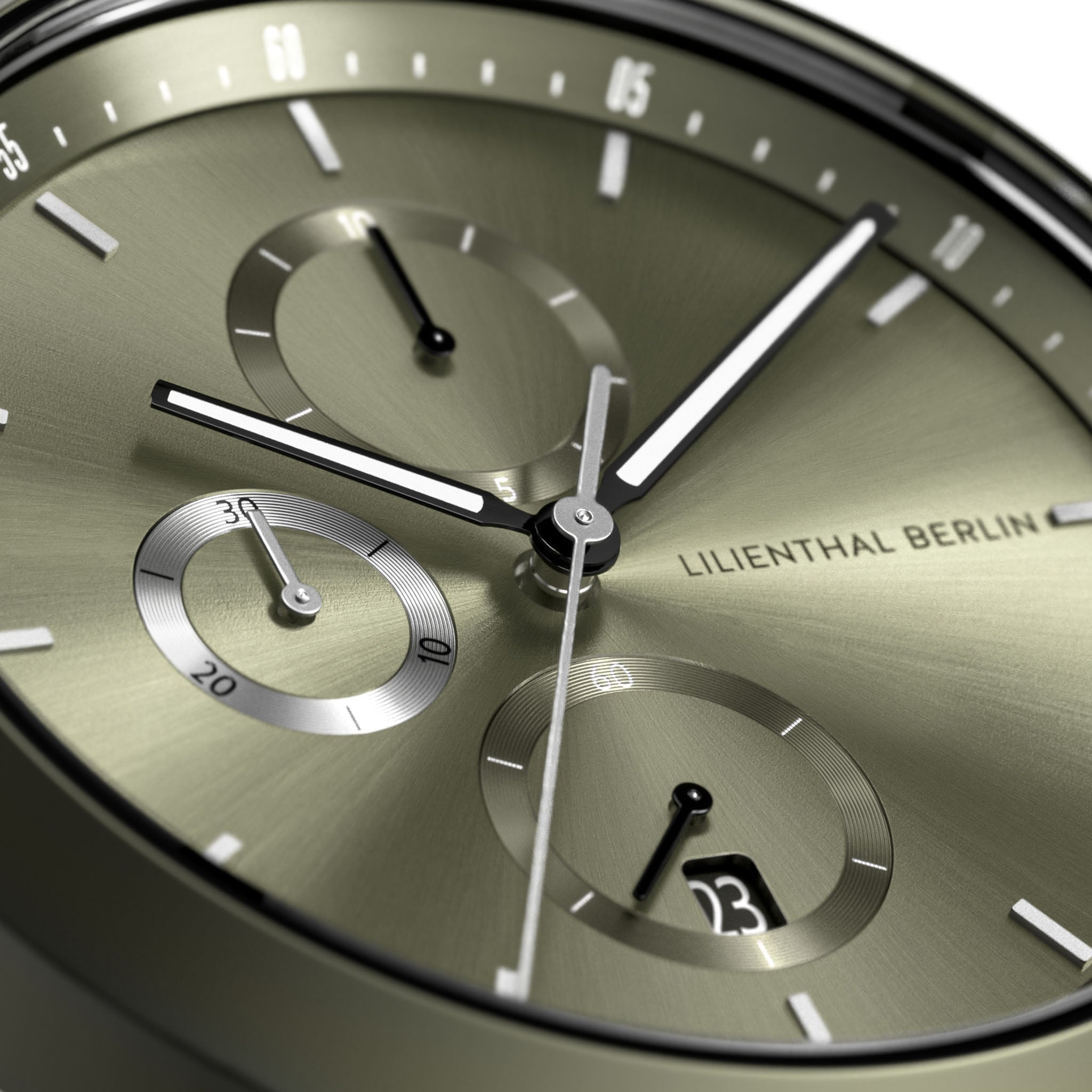 Close-up of an olive green chronograph watch face with subdials and date display