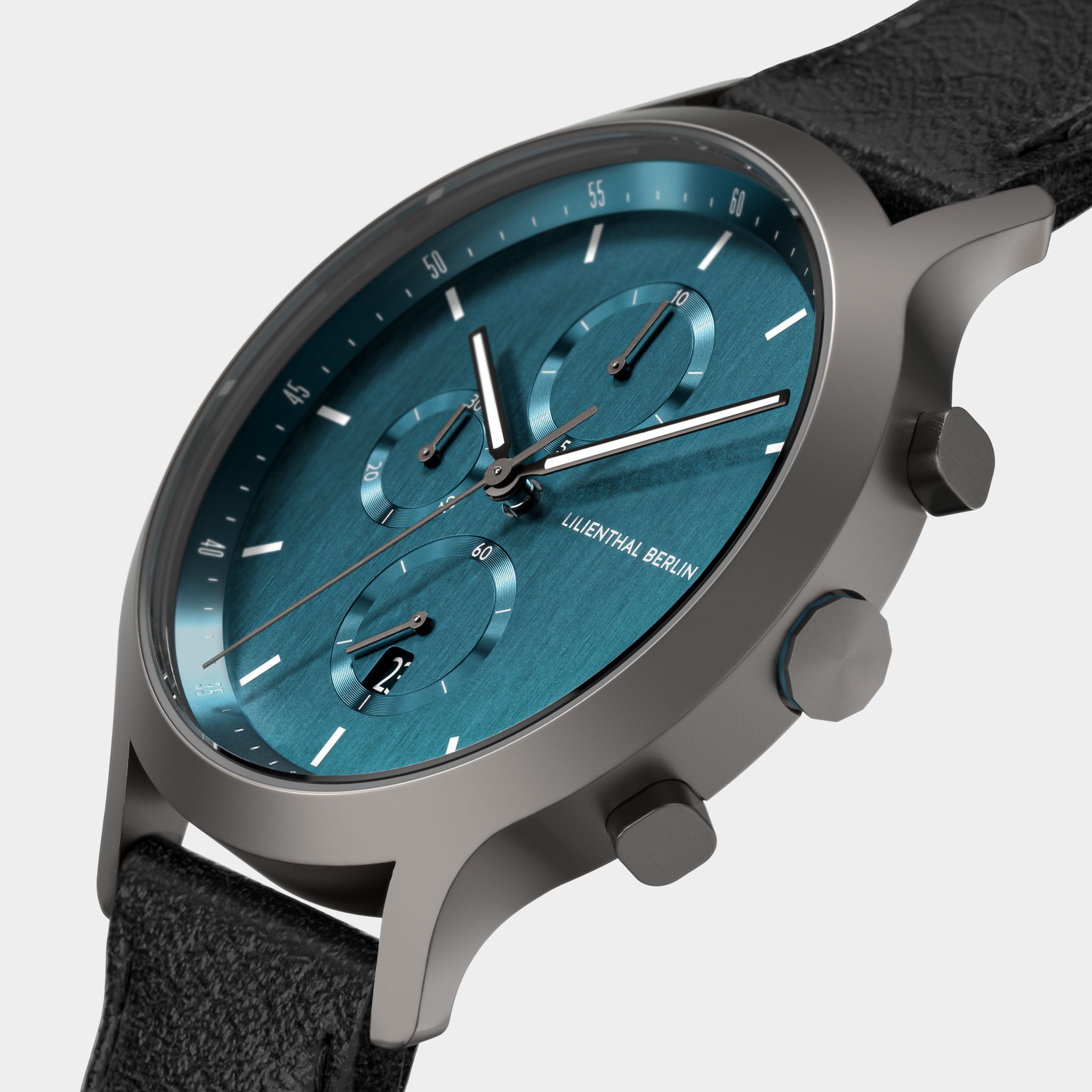 Close-up of modern chronograph wristwatch with teal blue dial and black leather strap