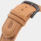 Close-up of tan leather watch strap with stitched edges and matte black buckle