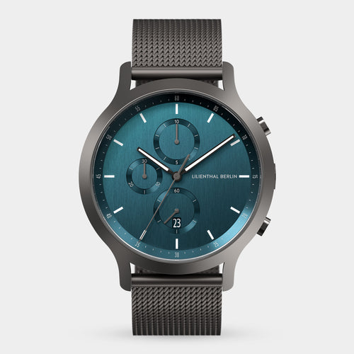 Men’s chronograph watch with a blue dial, subdials, date display, and mesh stainless steel strap