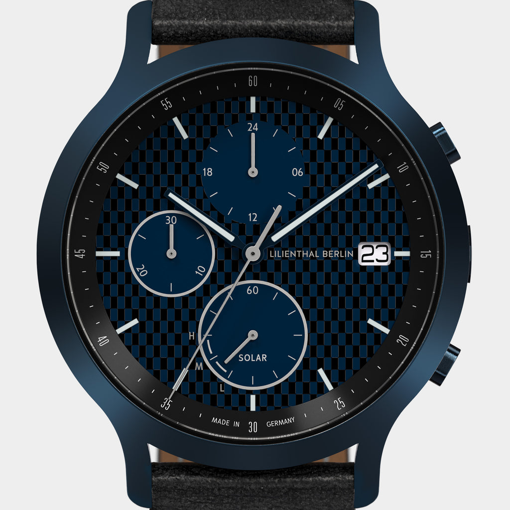 Blue chronograph solar watch with black checkered dial, subdials, and date display