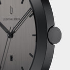 Close-up of minimalist black watch with brushed metal dial and date display