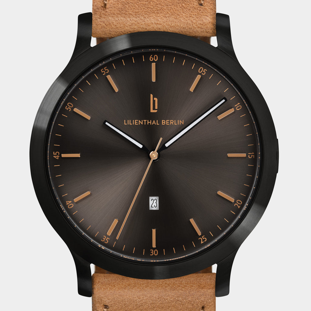 Brown sunburst dial wristwatch with date display and tan leather strap.