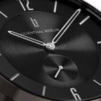 Close-up of a minimalist black watch face with silver hour and minute hands