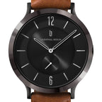 Black minimalist watch face with silver markers, brown leather strap, modern design