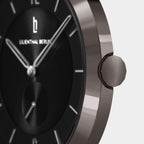 Close-up of a modern black watch face with silver hands and minimalist hour markers