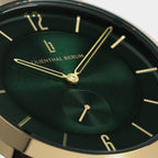 Close-up of luxury green watch face with gold hands and markers, minimalist design